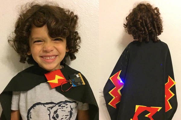 Child wearing a cape with micro:bit at the collar