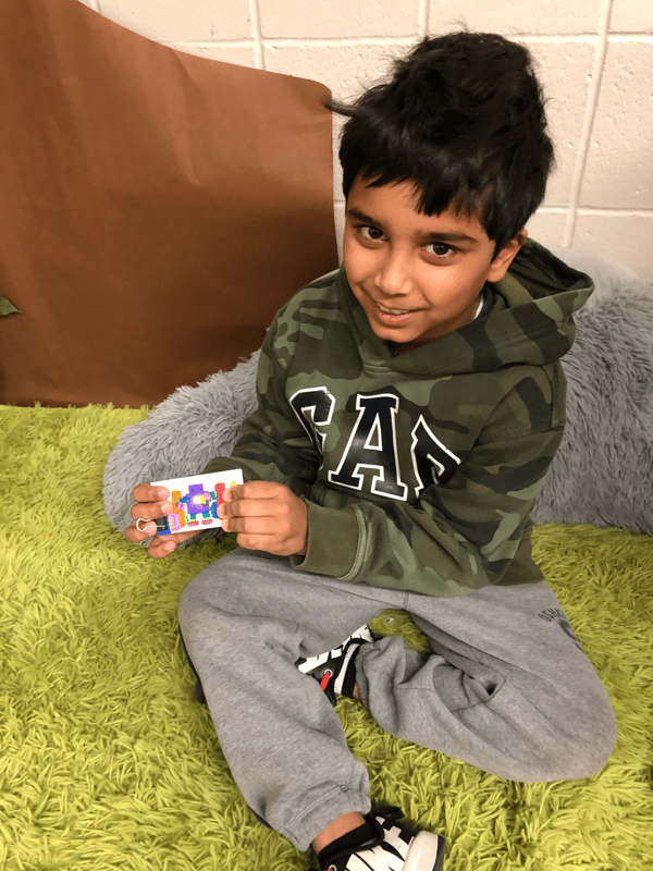 second grade boy showing off paper circuit