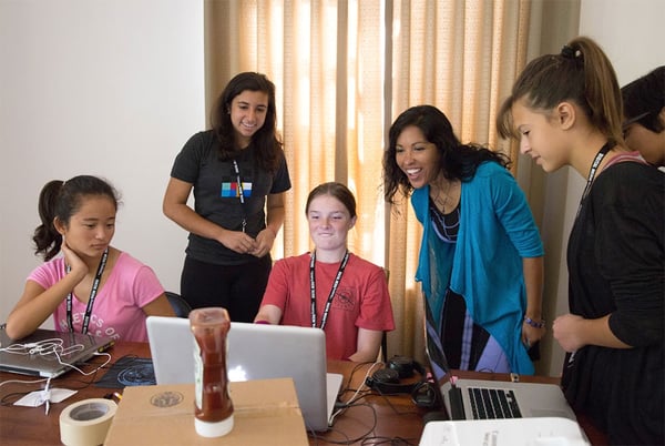 Made-by-Girls program graduate Uma B. teaching other students around a laptop