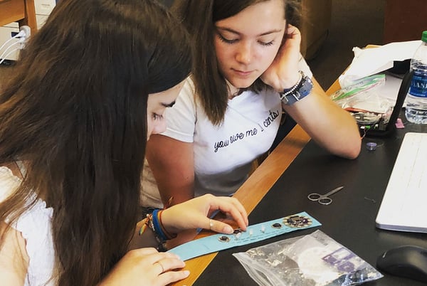 Two young women placing LilyPad components on a bracelet project